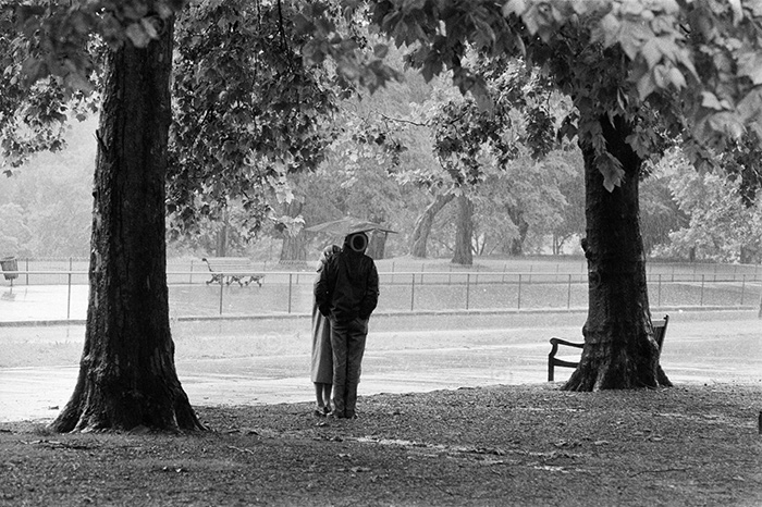 Hyde Park, London, 1979. Couple sheltering beneath Oak trees.