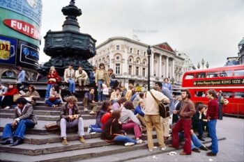 Piccadilly Circus, 1980, impromptu gig by group of music buskers on steps of the Piccadilly Circus Anteros statue roundabout in it's original location. At junction of Regent Street, Piccadilly, Shaftesbury Avenue, London