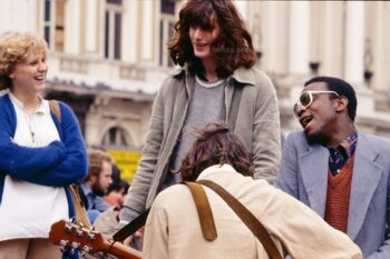 Piccadilly Circus, 1980, impromptu gig by group of music buskers on steps of the Piccadilly Circus Anteros statue roundabout in it's original location. At junction of Regent Street, Piccadilly, Shaftesbury Avenue, London