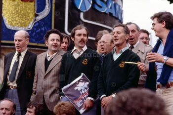 Several members of Risca Male Voice Choir from South Wales, UK. Public singing on steps of Anteros statue (also known as Eros) Piccadilly Circus, London, 1980.
