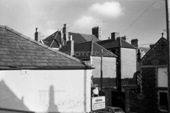 Urban rooftop chimneys and signage for J Sherlock & Sons motor repair garage in Cardiff, South Wales, UK.