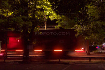 Night photo showing truck moving through Bowral town past the War Memorial on Station Street, at night with lights.