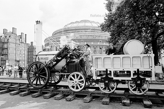 Replica of Stephenson's Rocket locomotive steam train with Albert Hall, London in background