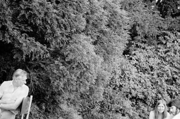 View of three people against a background of dense tree foliage. Picnic area, Symonds Yat, Monmouthshire, South Wales. 1975